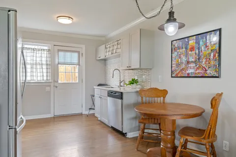 a kitchen with stainless steel appliances a dining table chairs and chandelier
