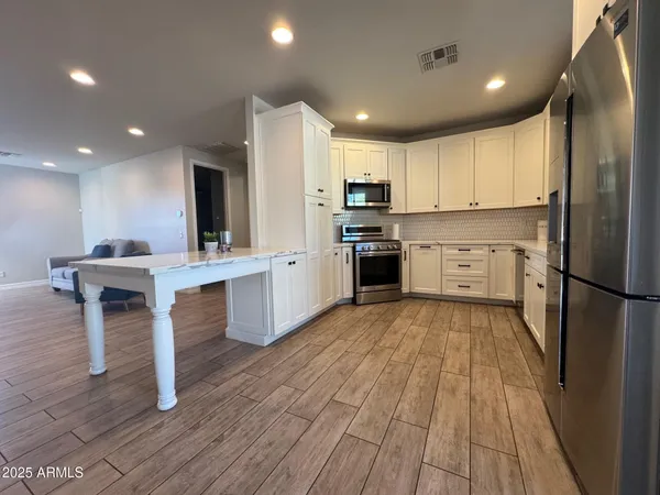 a kitchen with stainless steel appliances granite countertop a refrigerator sink and cabinets