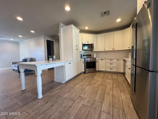 a kitchen with stainless steel appliances granite countertop a refrigerator sink and cabinets