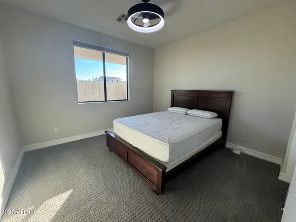 a bed sitting in a bedroom next to a window