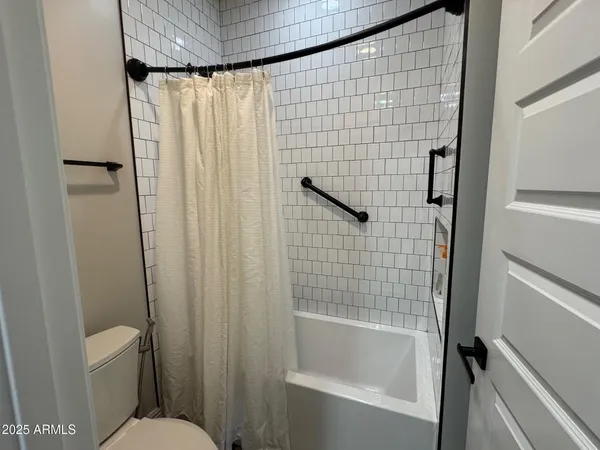 a bathroom with a shower curtain and a toilet