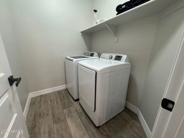 a utility room with wooden floor washer and dryer
