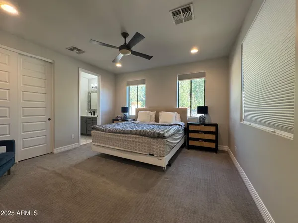 a spacious bedroom with a bed and a ceiling fan