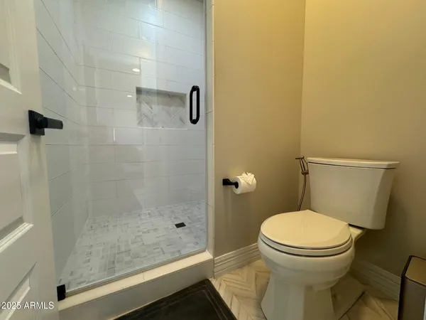 a bathroom with a toilet and a shower