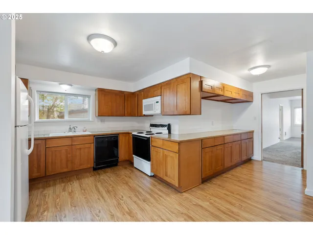 a kitchen with stainless steel appliances granite countertop a sink and wooden cabinets