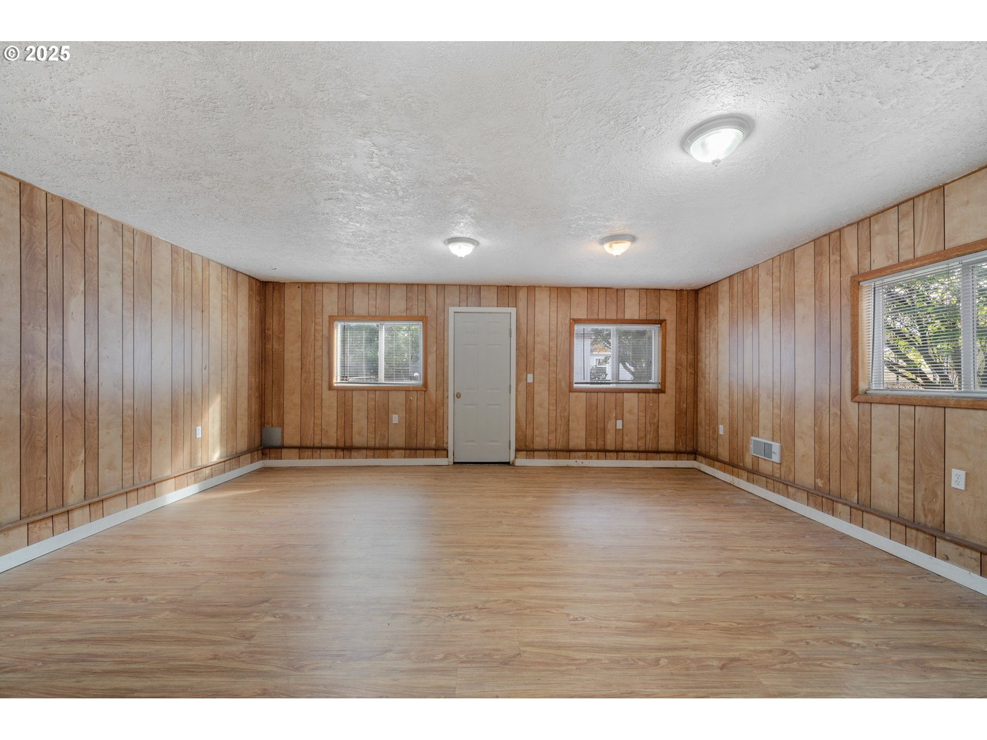 1307 3rd Street Tillamook, OR 97141 - Photo 21 of 42 a view of an empty room with a window and wooden floor