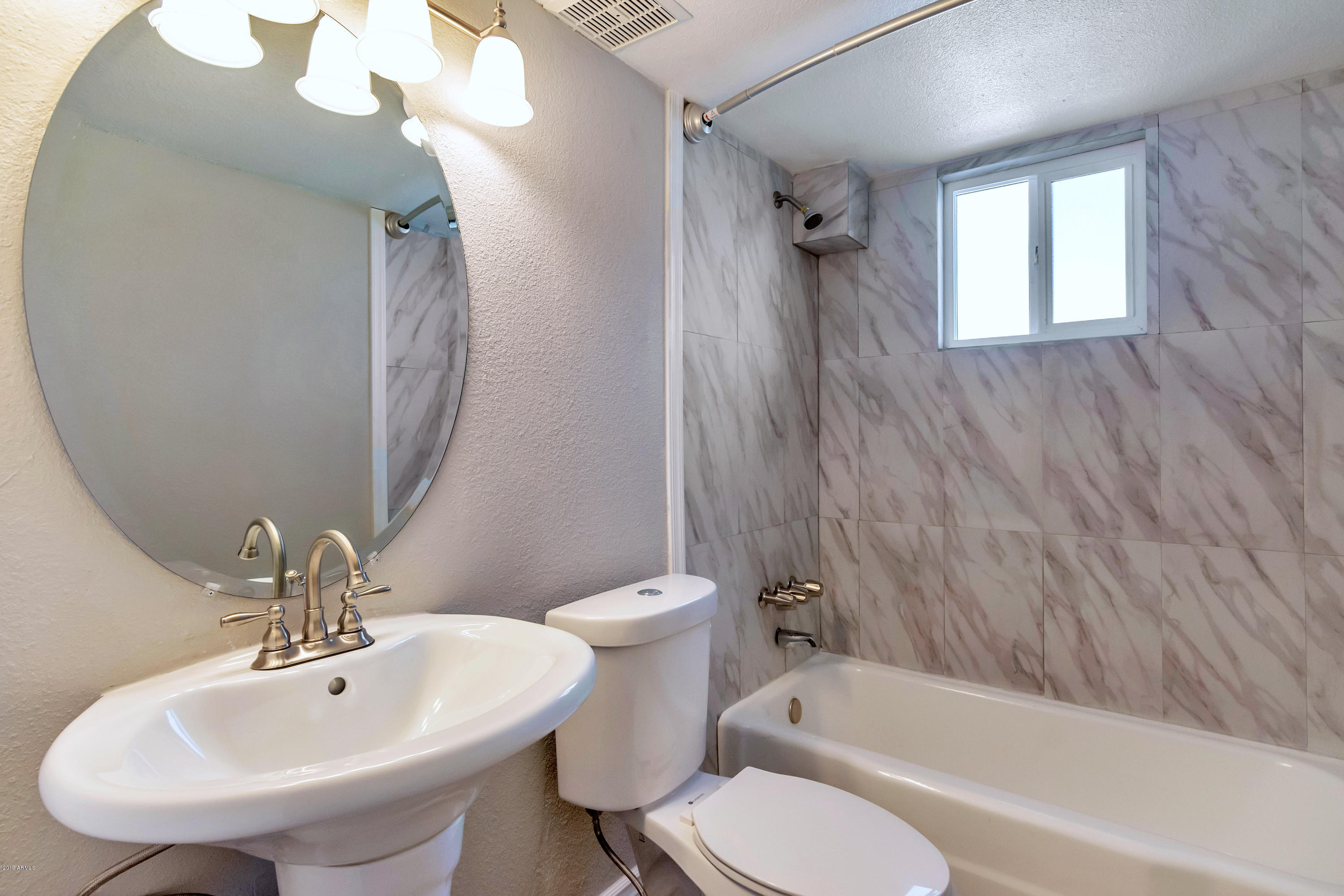 1942 West Berridge Lane Phoenix, AZ 85015 - Photo 11 of 13 a bathroom with a toilet a sink and bathtub