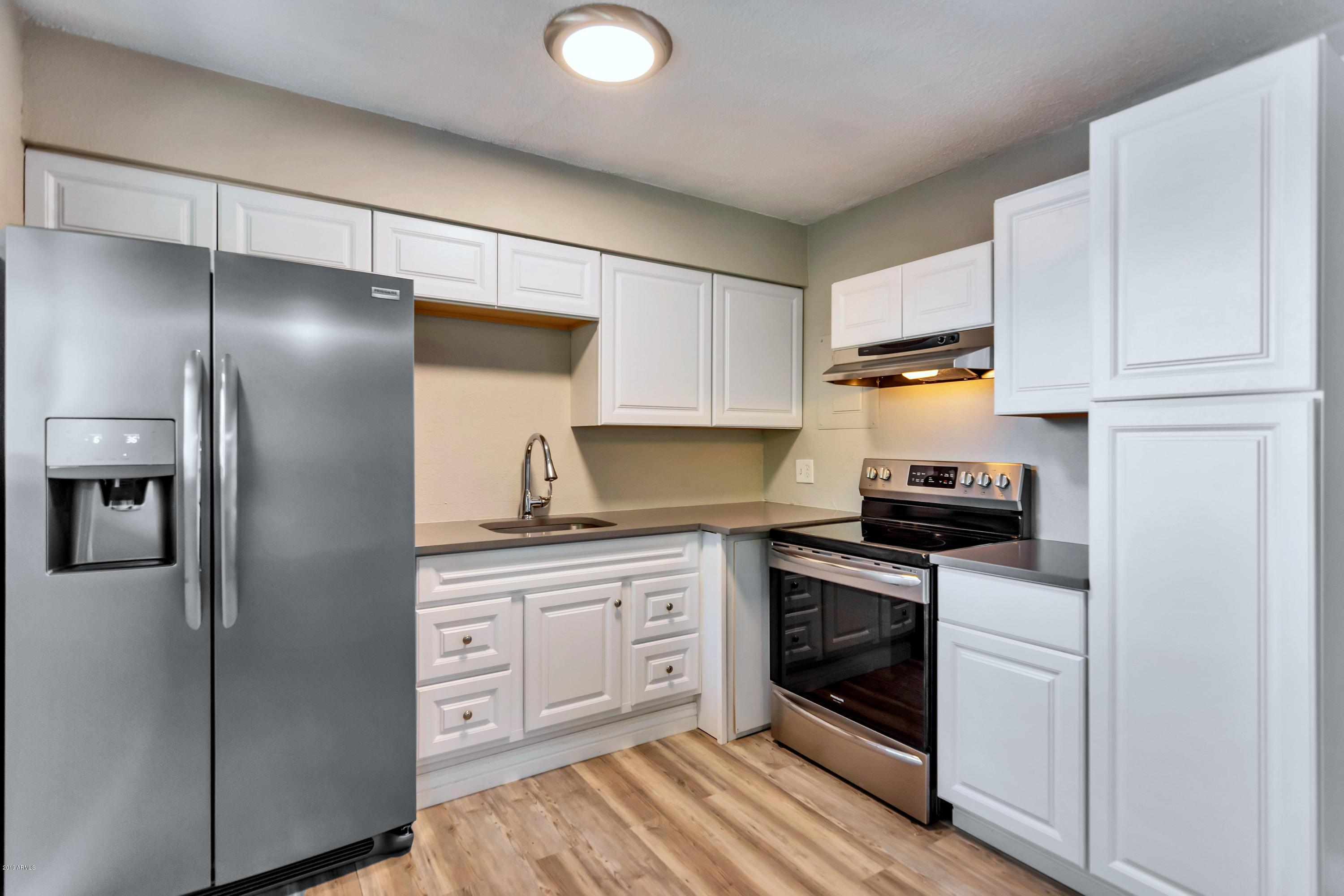 1942 West Berridge Lane Phoenix, AZ 85015 - Photo 6 of 13 a kitchen with stainless steel appliances a refrigerator sink and cabinets