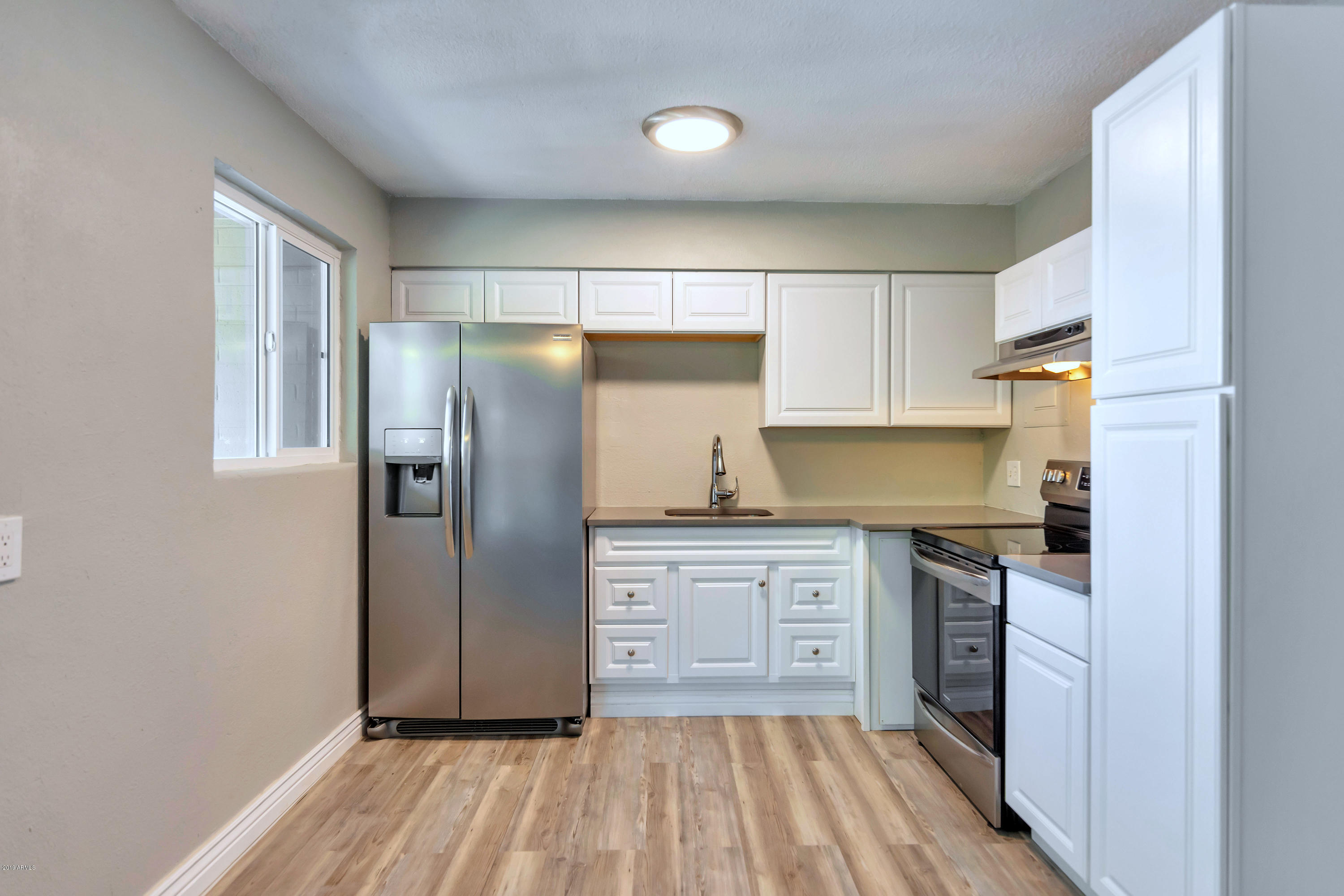 1942 West Berridge Lane Phoenix, AZ 85015 - Photo 9 of 13 a kitchen with granite countertop stainless steel appliances a refrigerator and cabinets
