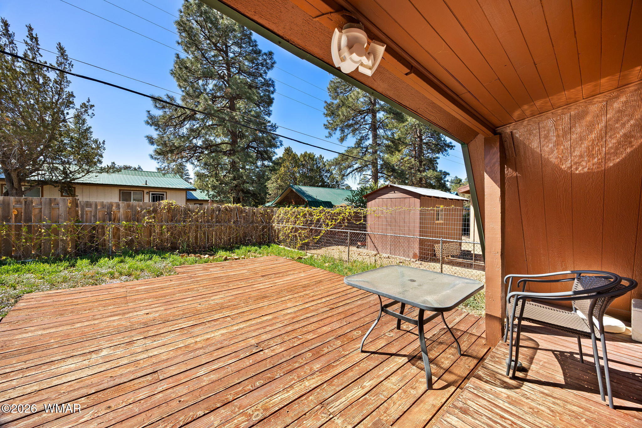 3355 Rim Lakes Drive Overgaard, AZ 85933 - Photo 19 of 37 a backyard of a house with table and chairs wooden floor and fence