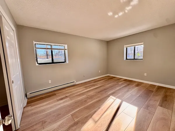a view of empty room with wooden floor
