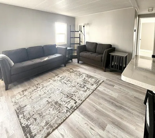 a living room with dining room and wooden floor