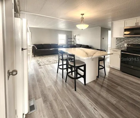 a kitchen with a table chairs refrigerator and microwave