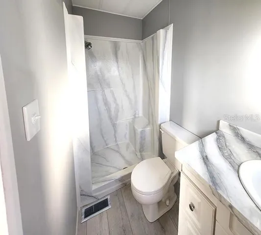 a spacious bedroom with a bed and a chandelier