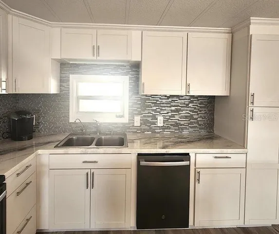 a kitchen with white cabinets and white appliances
