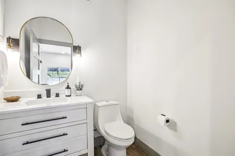 a bathroom with a toilet a sink and mirror