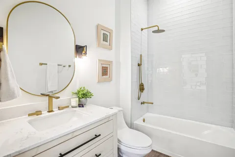 a bathroom with a sink mirror vanity and toilet