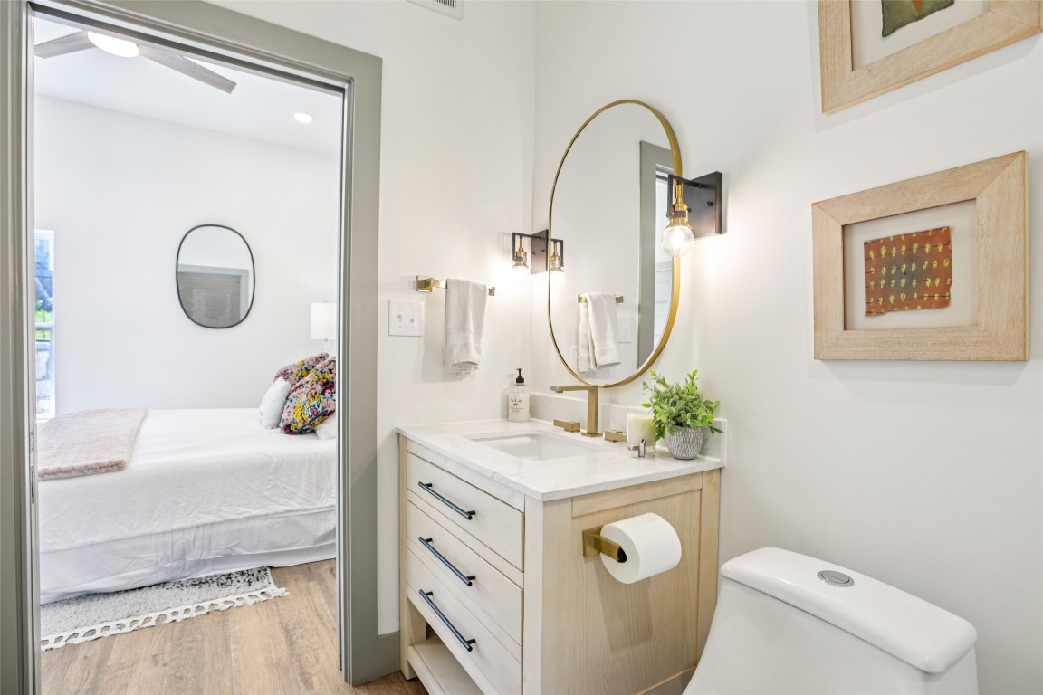 2450 Wickersham Lane, Unit 2011 Austin, TX 78741 - Photo 20 of 31 a bathroom with a sink mirror vanity and toilet