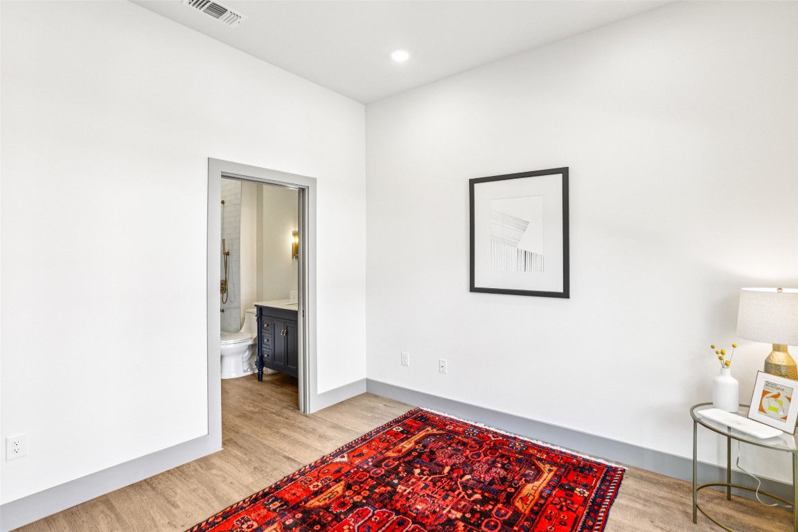 2450 Wickersham Lane, Unit 2011 Austin, TX 78741 - Photo 23 of 31 a view of a hallway with wooden floor and a bathroom