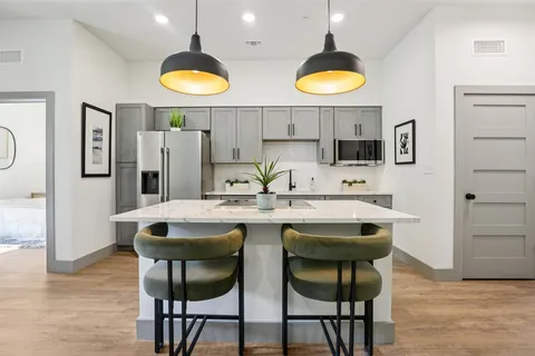 a kitchen with stainless steel appliances granite countertop a sink and a refrigerator