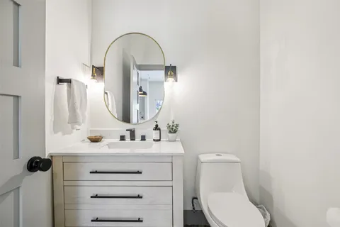 a bathroom with a toilet sink and mirror