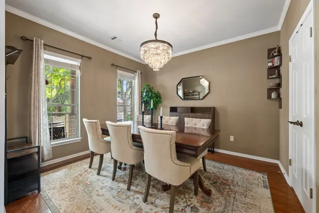 a dining room with wooden floor and chandelier