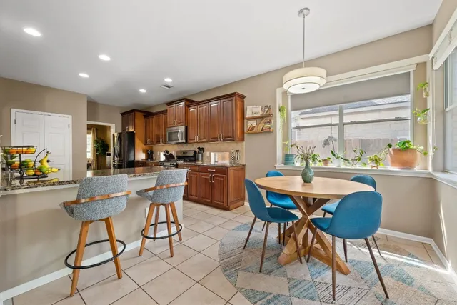 a kitchen with granite countertop a refrigerator a stove top oven and cabinets
