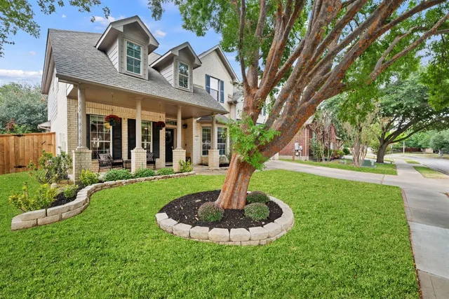 a front view of a house with a garden and trees