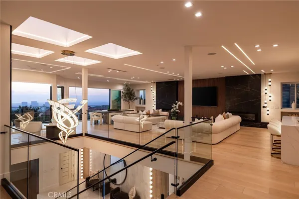 a living room with furniture a large window and wooden floor