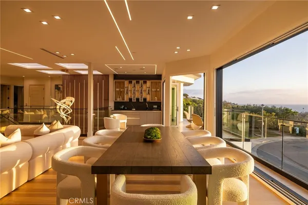 a bedroom with a bed and large windows with balcony view
