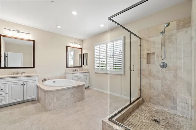 a spacious bathroom with a double vanity sink mirror and shower