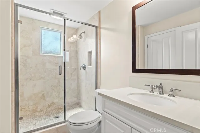 a bathroom with a granite countertop sink toilet and shower