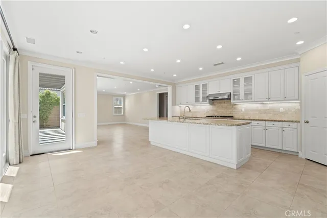 a large white kitchen with kitchen island a sink a center island stainless steel appliances and a cabinets