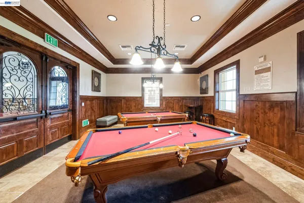 a room with pool table and windows