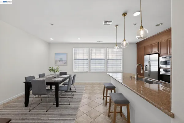 a kitchen with granite countertop a sink dining table and chairs
