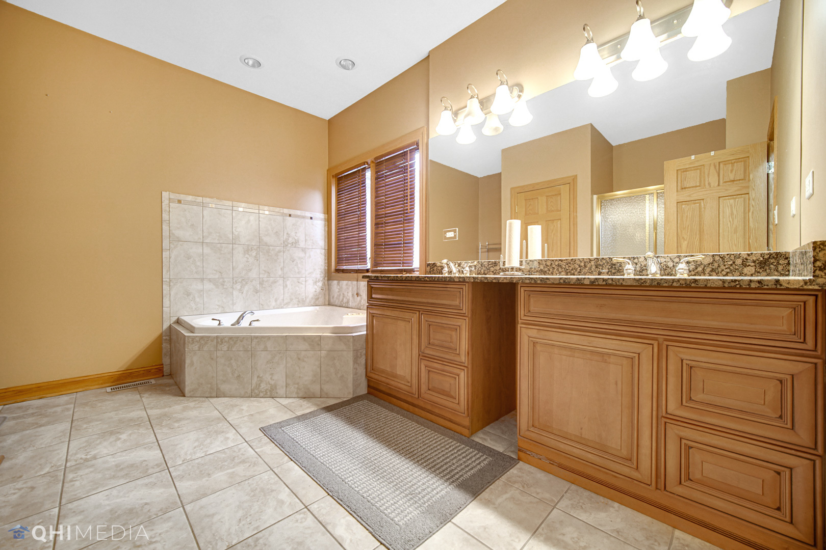 8832 South Roberts Road Hickory Hills, IL 60457 - Photo 8 of 16 a large bathroom with a double vanity sink a mirror and a bathtub