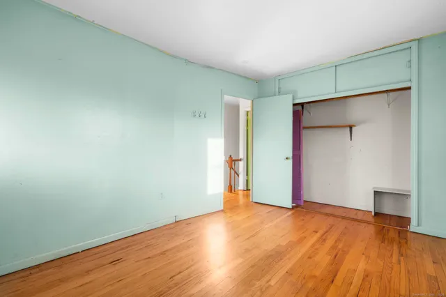 an empty room with wooden floor and closet