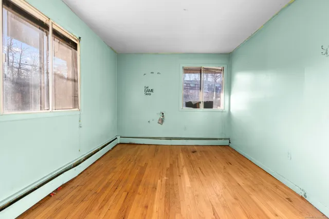 a view of a room with wooden floor and windows