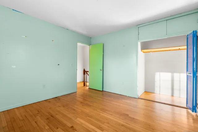 an empty room with wooden floor and a window