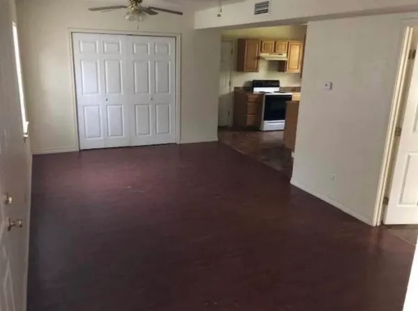an empty room with a kitchen and a window