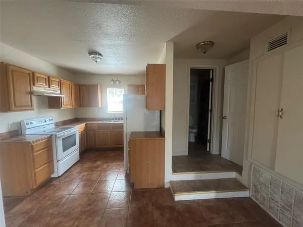 a kitchen with a refrigerator and a sink