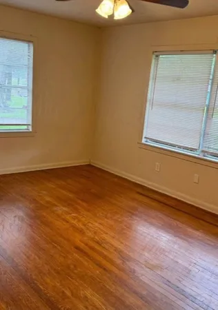 a view of a room that has wooden floor and a window