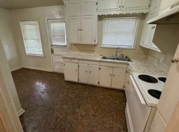 a kitchen with a sink a stove and cabinets