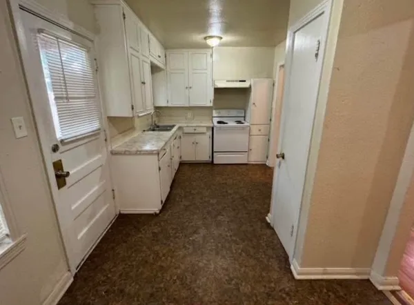 a kitchen with white cabinets and white appliances