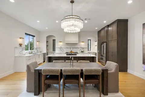a dining room with furniture a chandelier and wooden floor