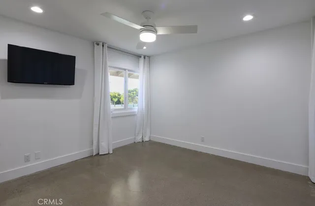an empty room with windows and flat screen tv