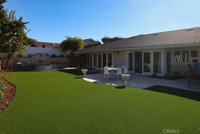 a backyard of a house with table and chairs
