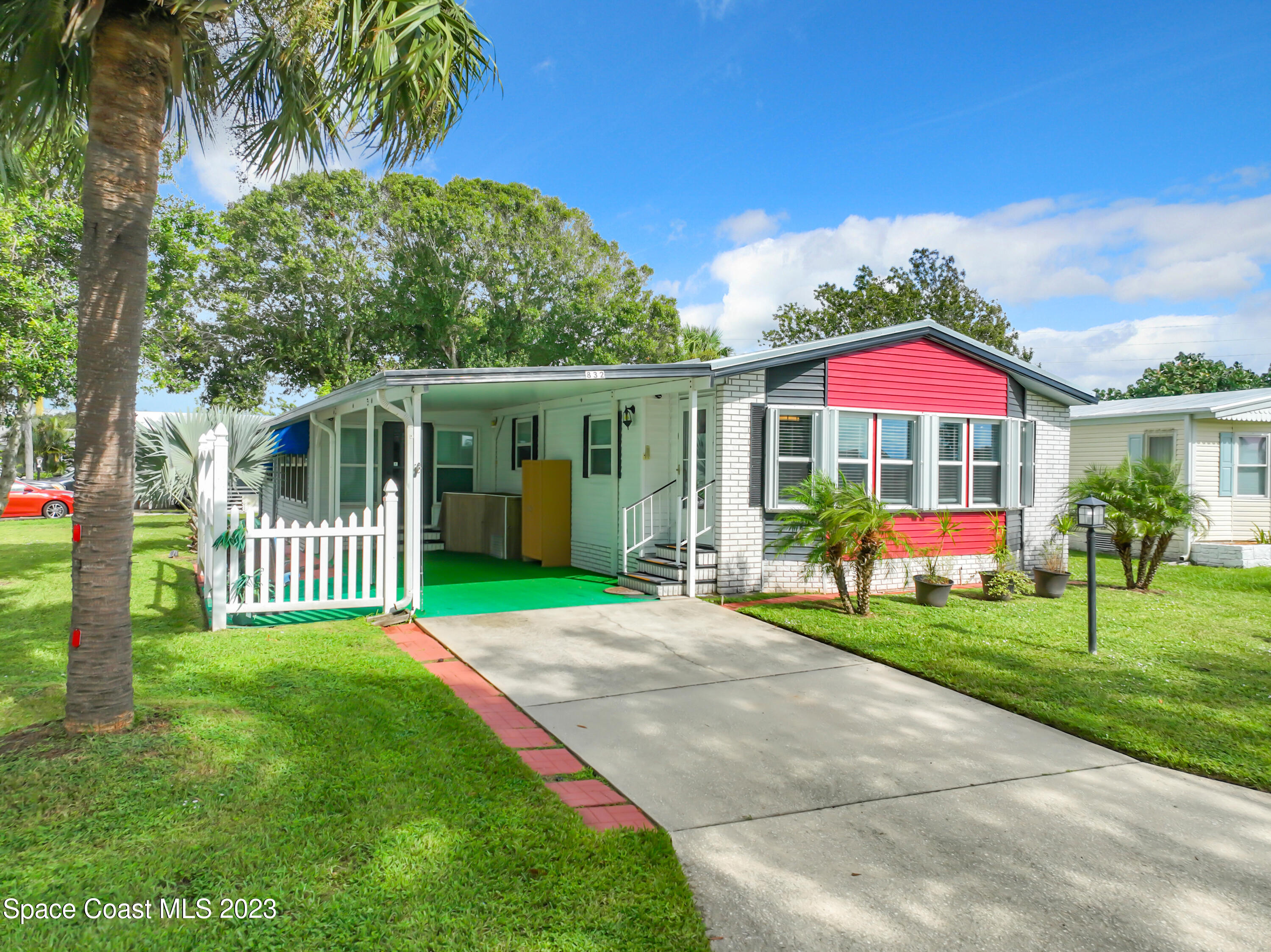 a view of a house with a yard and potted plants