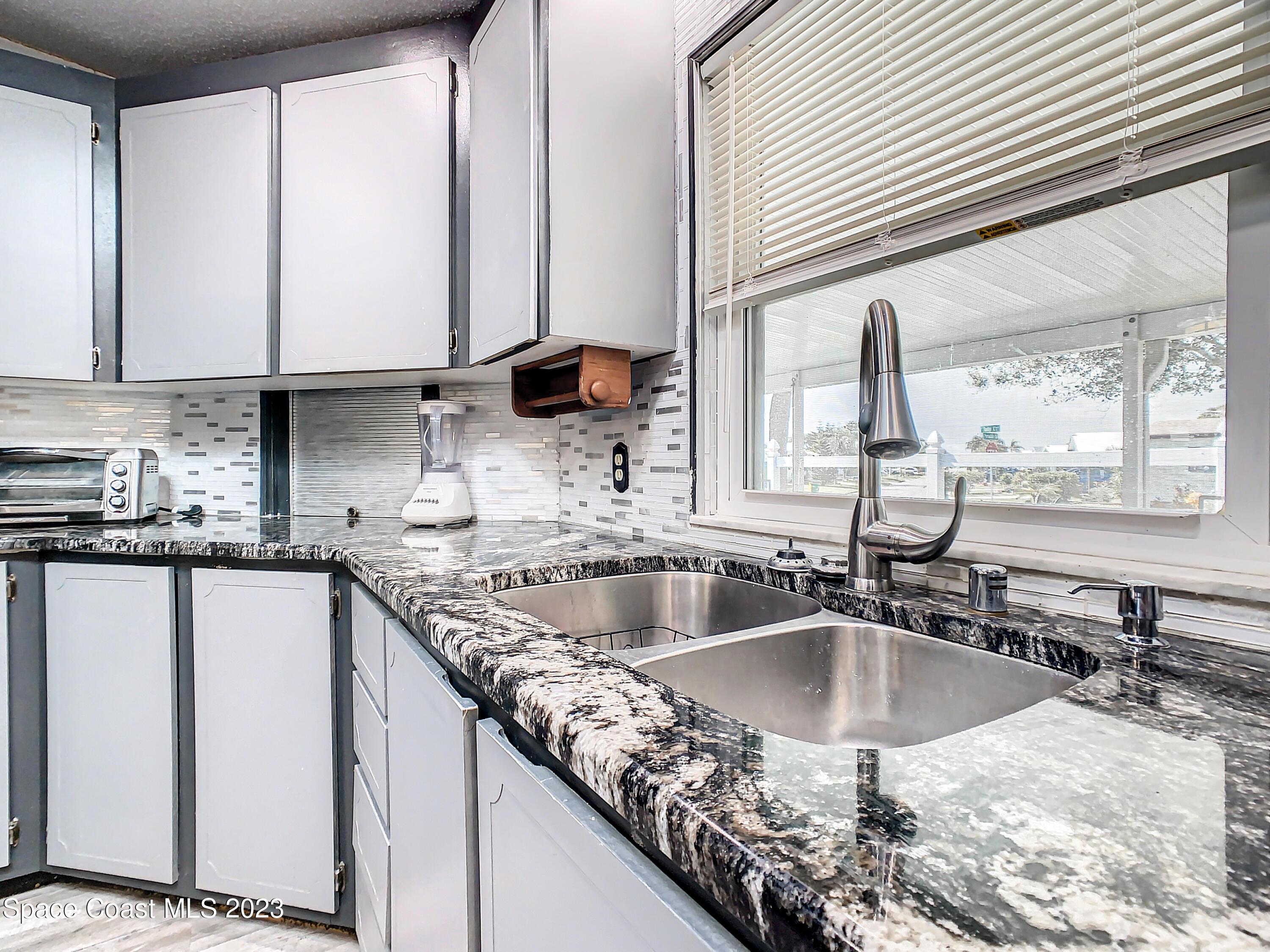 832 Periwinkle Circle Sebastian, FL 32976 - Photo 16 of 52 a kitchen with kitchen island granite countertop a sink a counter top space and cabinets