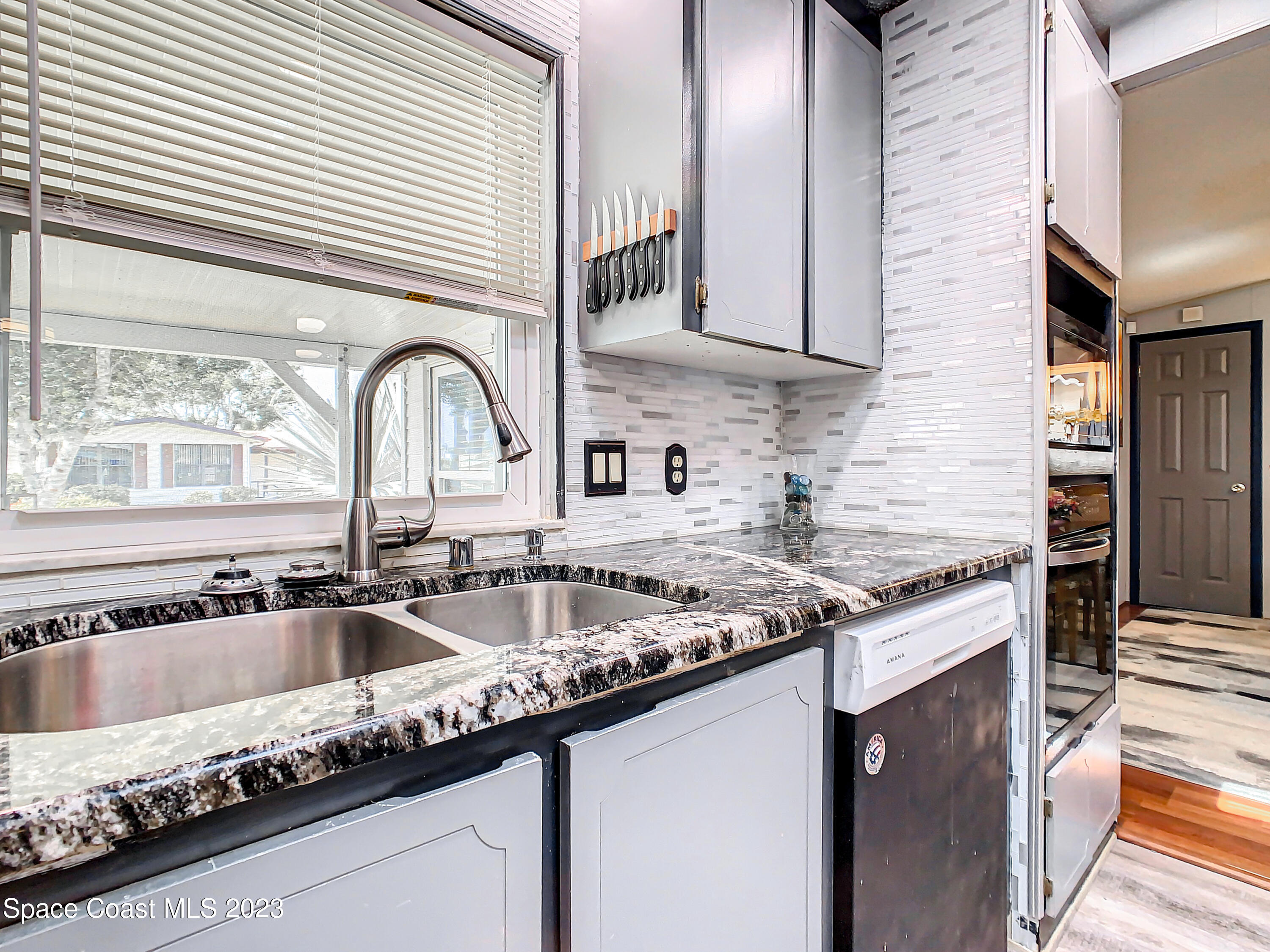 832 Periwinkle Circle Sebastian, FL 32976 - Photo 17 of 52 a kitchen with granite countertop stainless steel appliances a sink a stove and a window